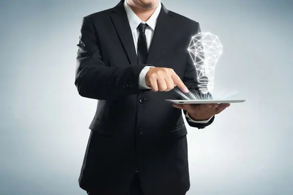A butler proffering a plate underneath a glowing digital lightbulb.
