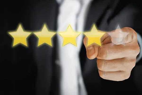 Five stars, four of which are yellow; the last is grey; a hand points towards the grey star.