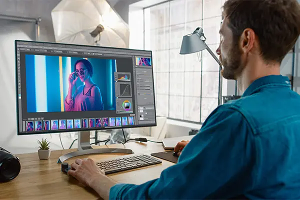 A man looks at a screen showing the Lightroom interface.