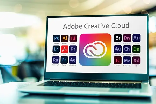 A laptop displaying 18 Adobe icons and the words Adobe Creative Cloud.