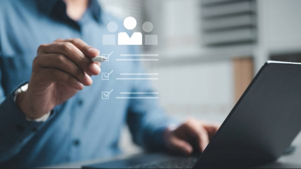 Person yn defnyddio gliniadur gydag eicon o restr wirio