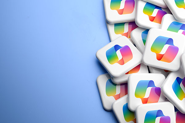 A stack of white square tiles on the right side of the image, each displaying a colourful gradient Copilot-style logo, set against a smooth blue gradient background with empty space on the left